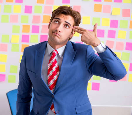 Young handsome man in conflicting priorities conceptの写真素材