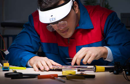 Computer specialist repairing PC late at night