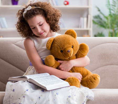 Little pretty girl reading books at homeの写真素材