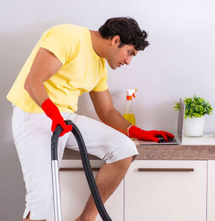 Young handsome man cleaning in the bedroom