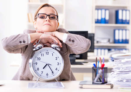 Businesswoman workaholic trying to finish urgent paperworkの写真素材