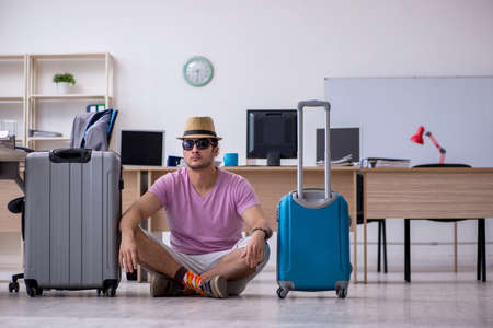 Young male employee preparing for the tripの写真素材
