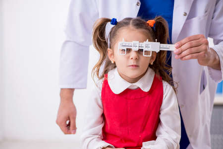 Small girl visiting young male doctor oculistの写真素材