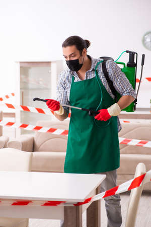 Young male sanitizer disinfecting indoorsの写真素材