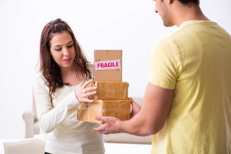 Young male courier delivering parcel to the officeの写真素材