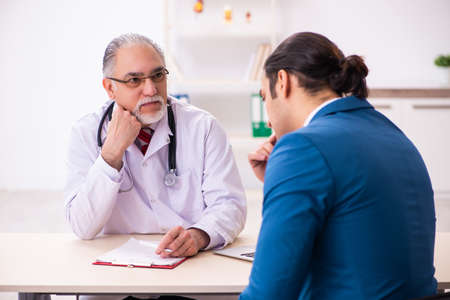 Young businessman meeting with old doctorの写真素材