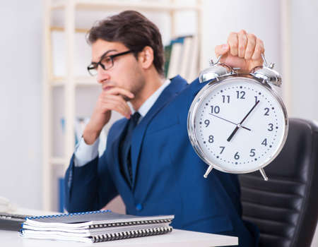 Businessman employee in urgency and deadline concept with alarmの写真素材