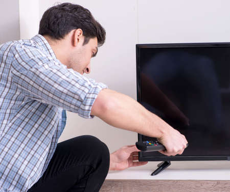 Man trying to fix broken tv