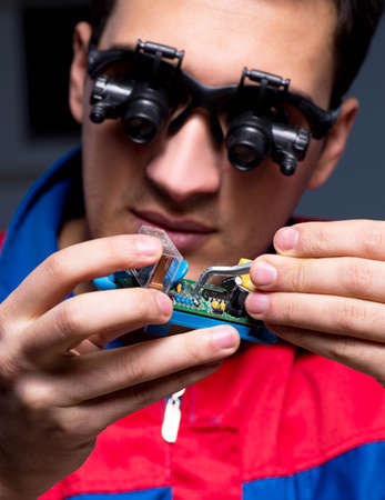 Computer specialist repairing PC late at night