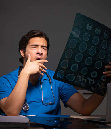 Young handsome doctor working night shift in hospital
