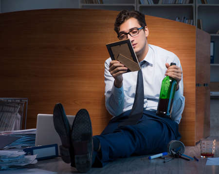 Sad employee in office missing his wife after divorce separation