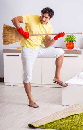 Young handsome man cleaning in the bedroomの写真素材
