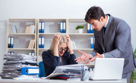 Angry irate boss yelling and shouting at his secretary employeeの写真素材