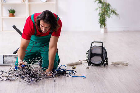 Funny young male electrician working indoorsの写真素材