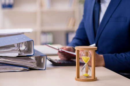 Young male employee in time management concept