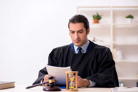 Young male judge in time management conceptの写真素材