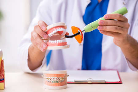 Young male dentist working in the clinic
