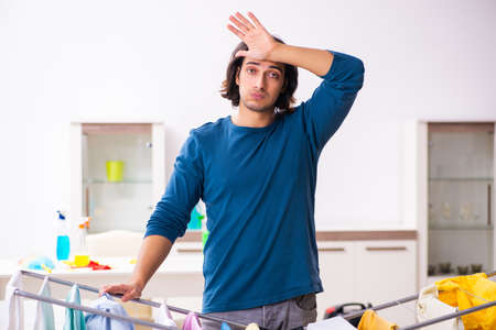 Young man husband doing clothing ironing at homeの写真素材