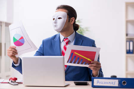 Male employee with mask in hipocrisy conceptの写真素材