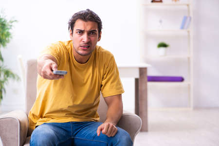 Young man watching tv at homeの写真素材
