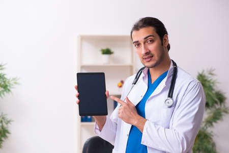 Young male doctor in telemedicine conceptの写真素材