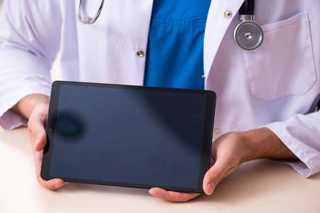 Young male doctor in telemedicine conceptの写真素材