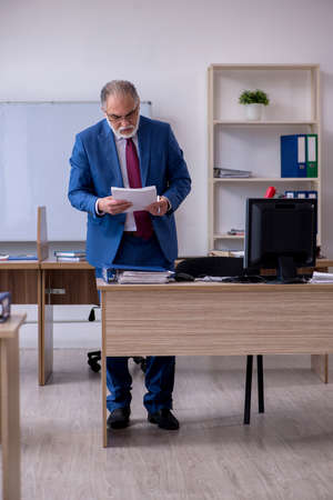 Old male boss employee working in the officeの写真素材