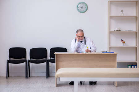 Old male doctor working in the clinicの写真素材