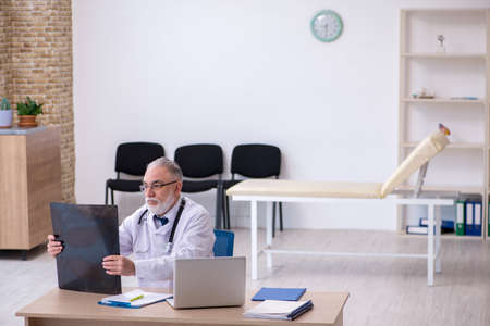 Old male doctor working in the clinicの写真素材