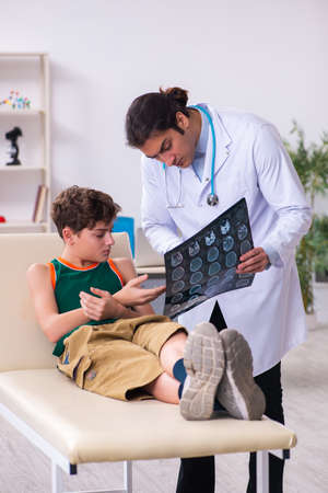 Sick boy visiting young male doctor pediatricianの写真素材