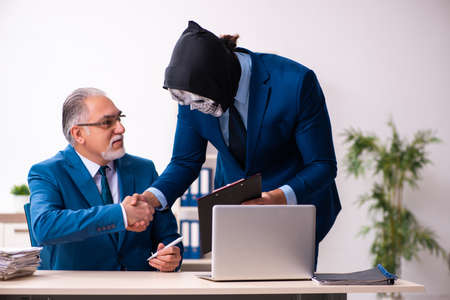 Old businessman employee getting deal with the devilの写真素材