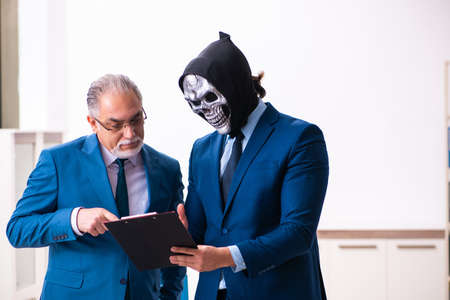 Old businessman employee getting deal with the devilの写真素材
