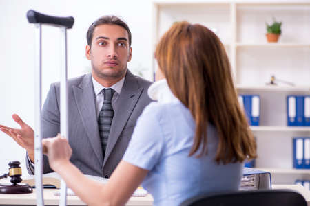 Young injured woman and male lawyer in the courtroomの写真素材