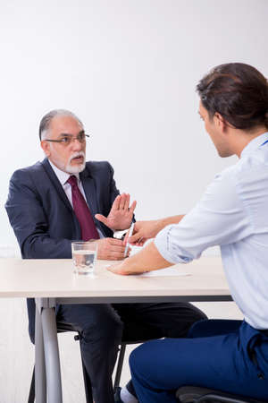 Old businessman meeting with advocate in pre-trial detentionの写真素材