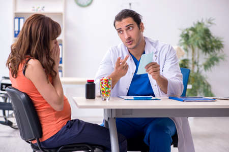 Pregnant woman visiting male doctor gynecologistの写真素材