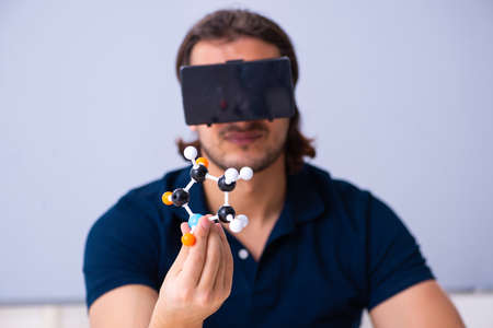 Young male scientist sitting in the classroomの写真素材