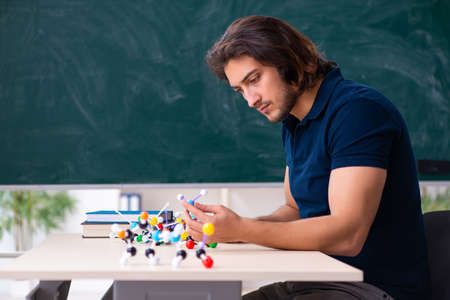 Young male scientist sitting in the classroom