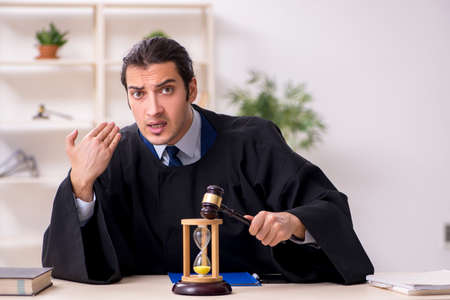 Young male judge in time management conceptの写真素材