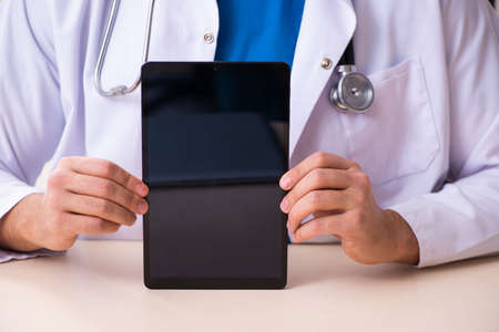 Young male doctor in telemedicine conceptの写真素材