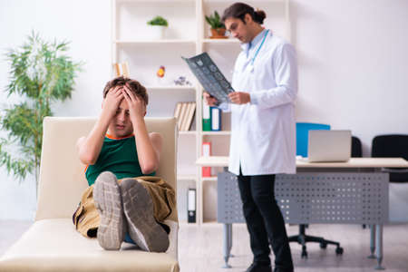 Sick boy visiting young male doctor pediatricianの写真素材