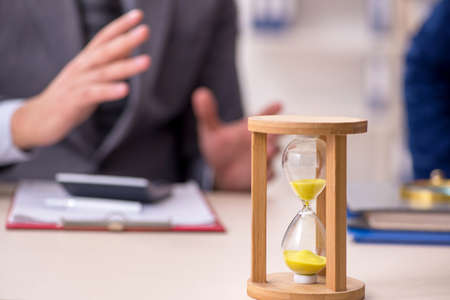 Two businessmen in time management conceptの写真素材