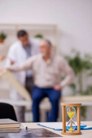 Old male patient visiting young doctor in time management concep