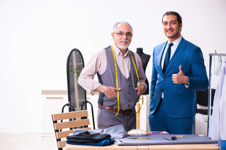 Young businessman visiting old male tailorの写真素材