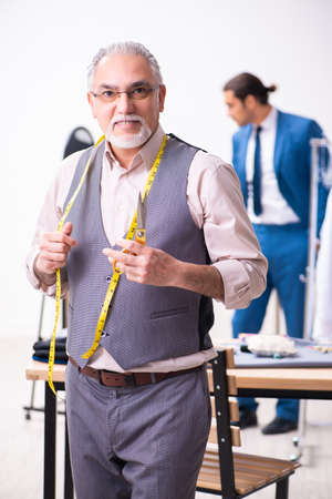 Young businessman visiting old male tailorの写真素材