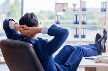 Young handsome businessman employee working in office at deskの素材 [FY310152241723]