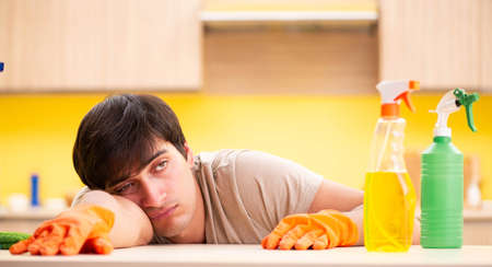 Single man cleaning kitchen at home