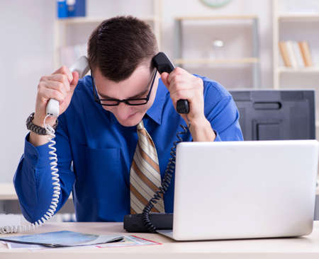 Young businessman employee working in office at deskの写真素材