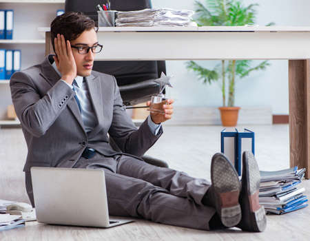Young handsome employee sitting on the floor in the officeの写真素材