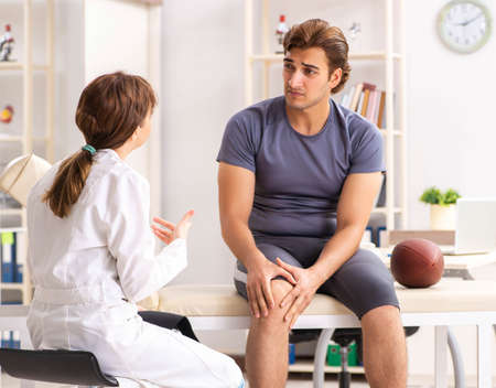 Handsome american footbal player visiting female doctor traumatoの写真素材