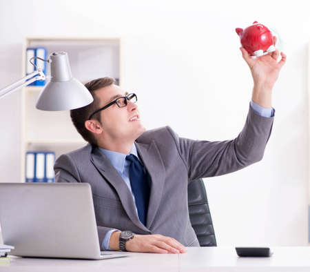 Young employee with piggybank in pension savings conceptの写真素材